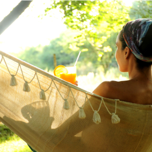 En kvinna som kopplar av med en drink i en hängmatta på Surfviken