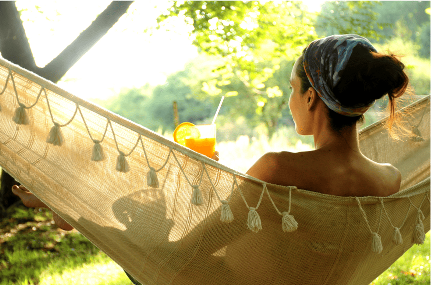 En kvinna som kopplar av med en drink i en hängmatta på Surfviken