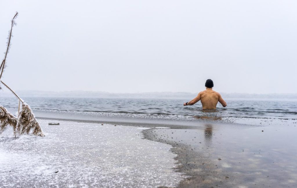 Ice swimming Fit man goes ice swimming into a lake