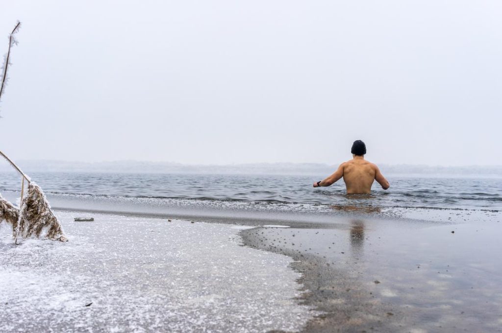 Ice swimming Fit man goes ice swimming into a lake